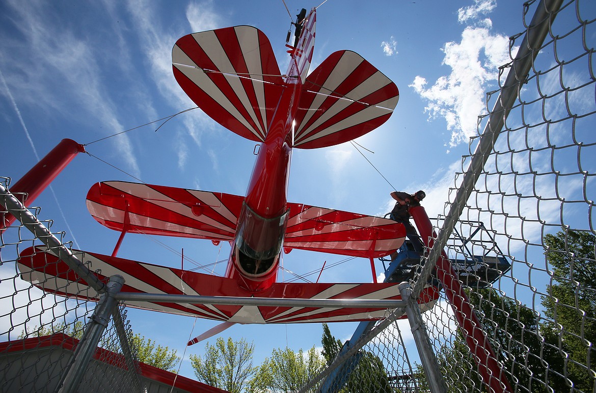 Silverwood Theme Park maintenance lead Paul Reid works on a decorative installation Thursday in Coaster Alley. The newest coaster, Stunt Pilot, officially opens to the public Saturday.