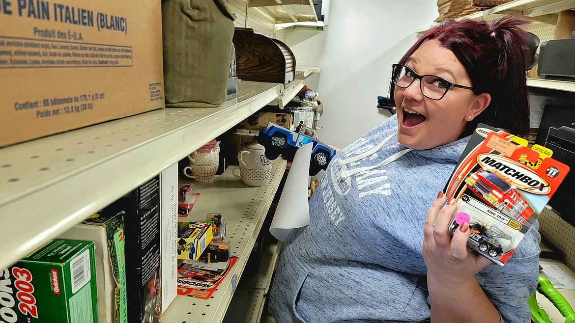 Courtesy photo
Product photographer Shelby Barker shows off some of the items available at BidMore2Win Auctions, in Suite 14 of Fairgrounds Center at 4055 N. Government Way.