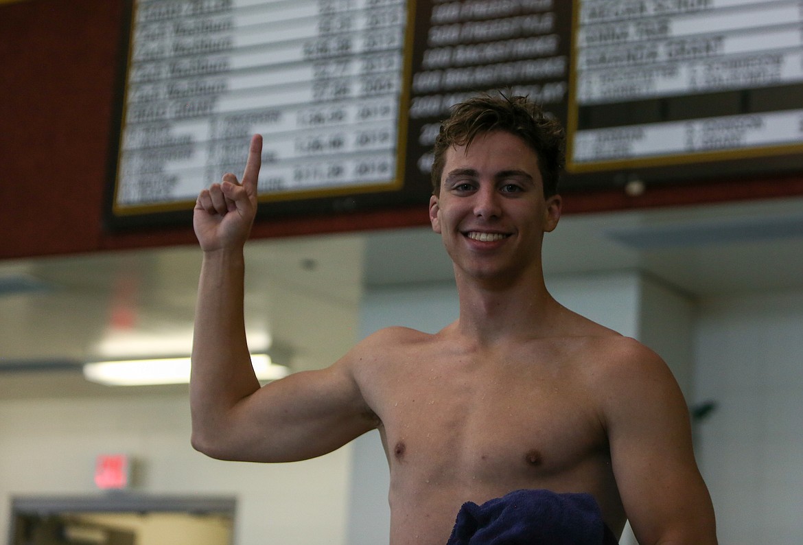 Moses Lake High School senior Zach Washburn holds up a "number one" in front of the school record board at the Tony St. Onge Pool of Dreams at MLHS on Thursday afternoon after claiming the final individual record time in the 100 yard breaststroke.