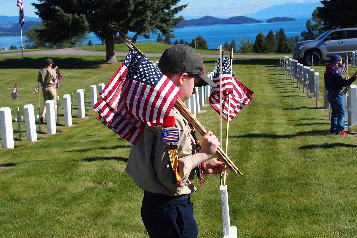 Members of Boy Scouts Polson Troop 1947 were among those working with Honor Guard and others Saturday morning placing approximately 500 flags and crosses on military headstones at Lakeview Cemetery in Polson. (Emily Lonnevik/Lake County Leader)