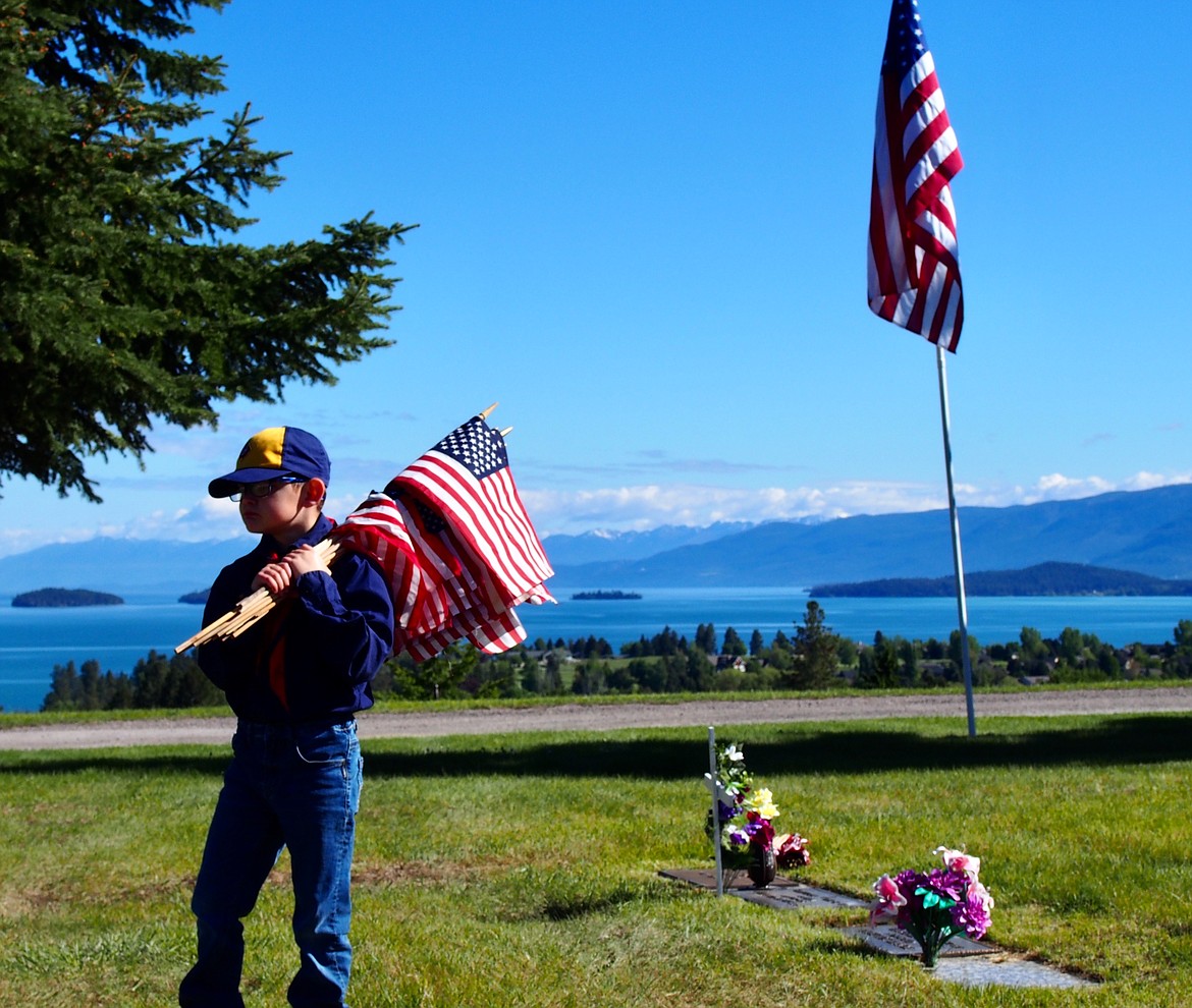 Members of Boy Scouts Polson Troop 1947 were among those working with Honor Guard and others Saturday morning placing approximately 500 flags and crosses on military headstones at Lakeview Cemetery in Polson. (Emily Lonnevik/Lake County Leader)