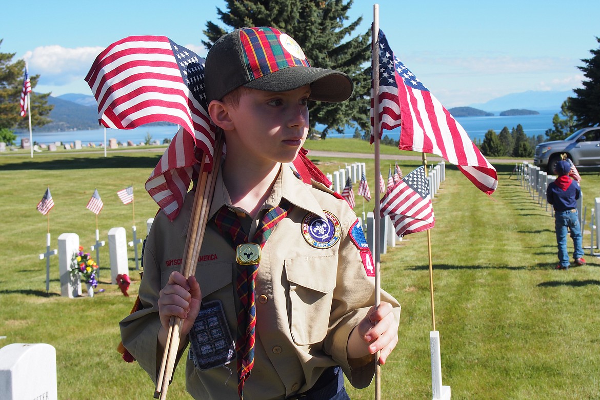 Members of Boy Scouts Polson Troop 1947 were among those working with Honor Guard and others Saturday morning placing approximately 500 flags and crosses on military headstones at Lakeview Cemetery in Polson. (Emily Lonnevik/Lake County Leader)