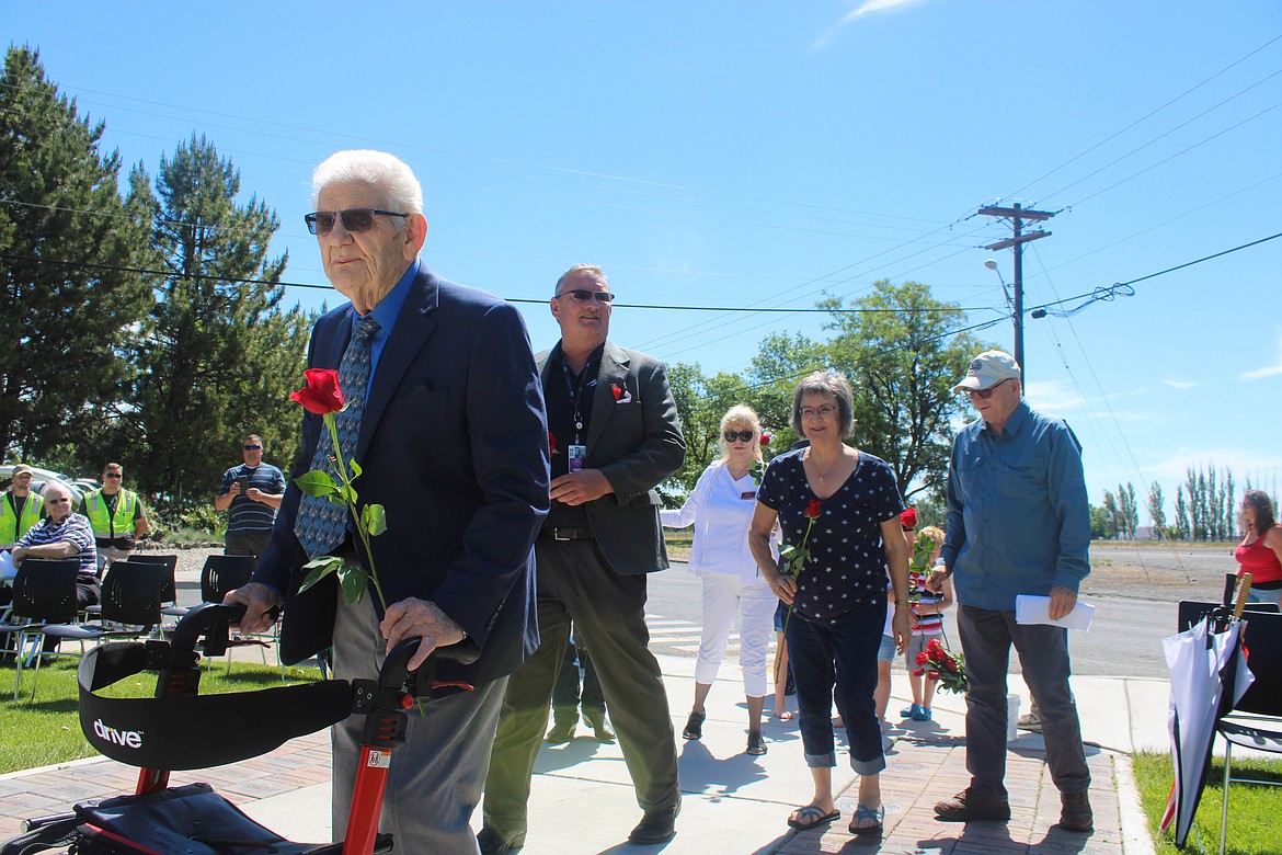 Former Staff Sergeant Ralph Boyden, one of the first to the scene of the 1952 crash, leads the line of roses to place for each of the fallen soldiers at the Memorial Day service at the 87 Forgotten Heroes Memorial in Moses Lake.