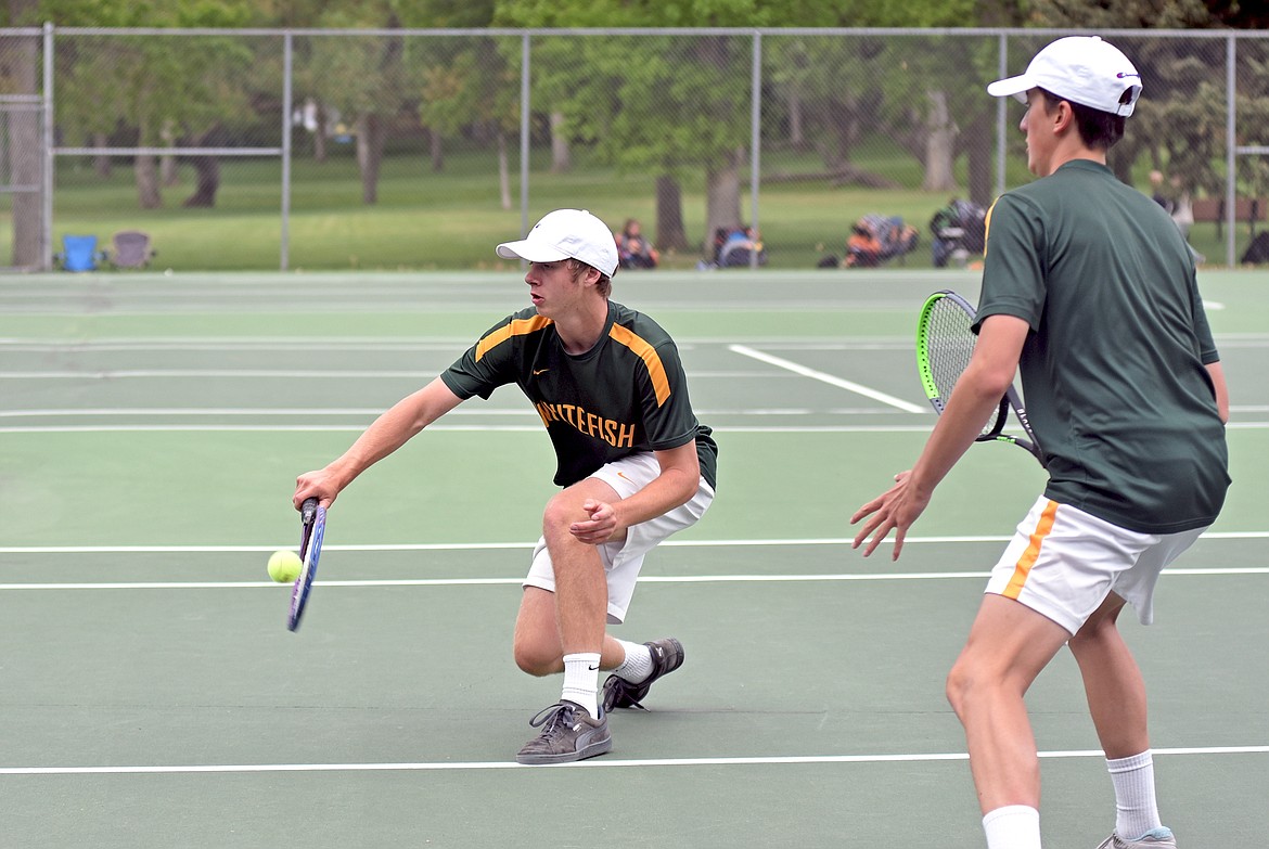 Whitefish's Aaron Dicks hits a volley as as his partner Highland Lee-French watches while playing in a doubles match during the State A tennis tournament in Billings on Friday. (Whitney England/Whitefish Pilot)