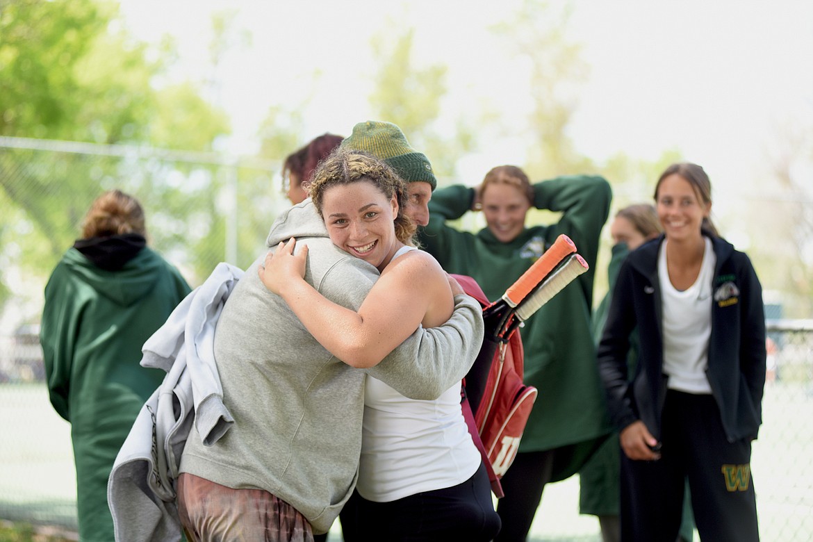 Lady Bulldog Gracie Smyley hugs her coach Patrick Dryden and is congratulated by her teammates after becoming a repeat state champion at the State A tennis tournament in Billings on Friday. (Whitney England/Whitefish Pilot)