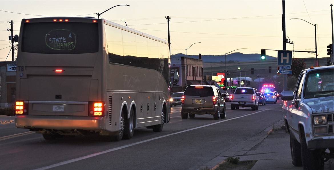 The Polson softball team bus is escorted down Highway 93 toward Main Street in Polson upon arriving back home Saturday night. (Scot Heisel/Lake County Leader)