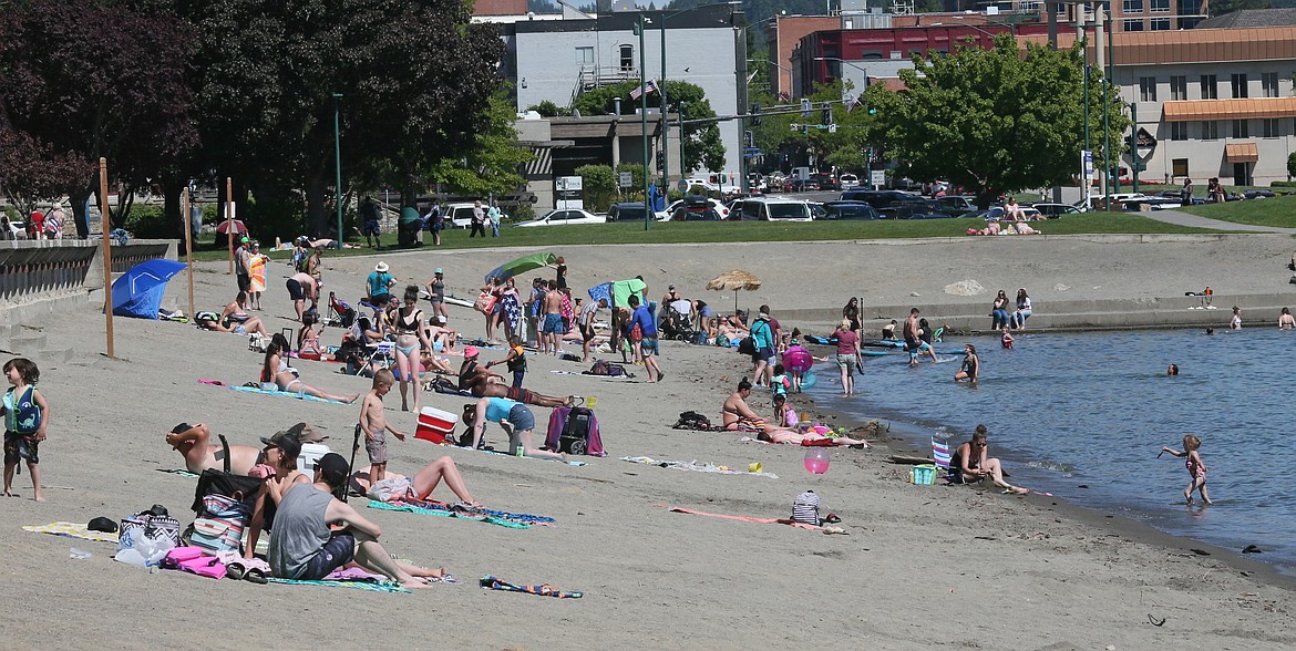 Sunbathers enjoy mid-80s weather Tuesday at City Beach. Multiple reports of women going topless along Coeur d'Alene's beaches over the Memorial Day weekend prompted a look into Idaho's indecent exposure law, which doesn't prohibit men or women from going topless. (DEVIN WEEKS/Press)