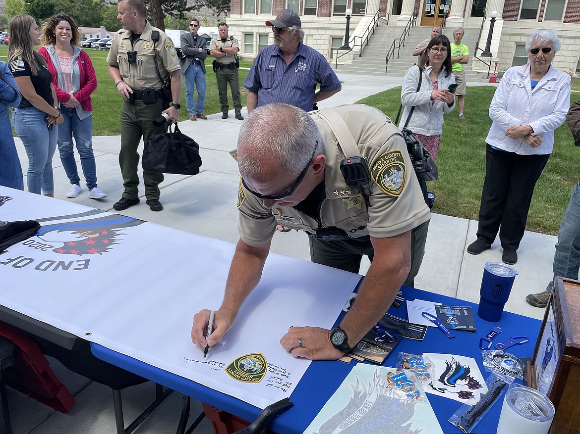 Grant County Sheriff Tom Jones signs a memorial banner on Friday as part of the End of Watch Ride to Remember.