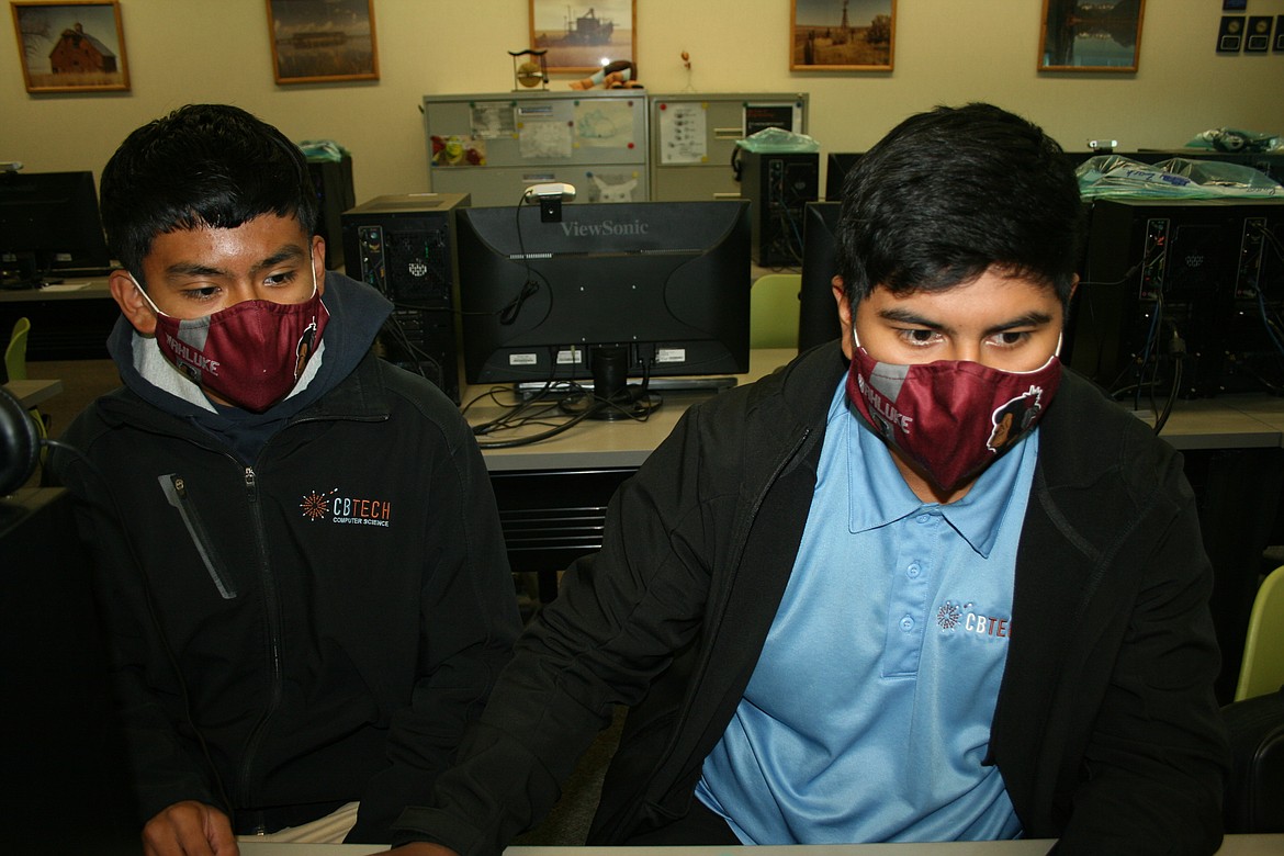 Wahluke High School juniors Roberto Santos (left) and Angel Torres (right) check their work during video game programming class at Columbia Basin Technical Skills Center. The two collaborated on a video game design that earned them seventh place in state FBLA competition. Santos also qualified for nationals in a separate category.