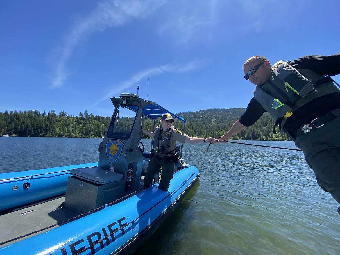 Kootenai County Recreation Safety Supervisor Sgt. Ryan Miller, right, hands off a rope to seasonal Marine Deputy Karen Perkins Sunday afternoon. (MADISON HARDY/Press)