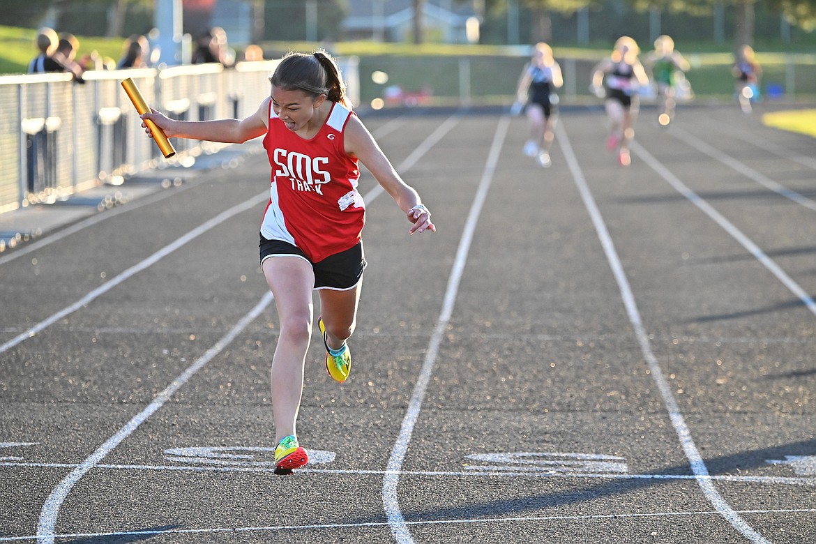 Eighth grader Fiona MacDonald crosses the finish in a relay during the middle school district track meet on May 13.