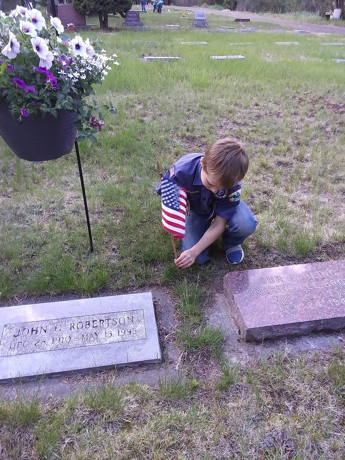 (Photo courtesy of Tiffani Beggerly)
Nolen Beggerly placing flags along graves of Veterans.