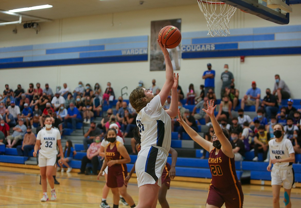 Warden High School's Rylee McKay puts a shot up near the rim in the fourth quarter of the Cougars' 78-52 win over visiting Moses Lake High School at home on Wednesday evening.