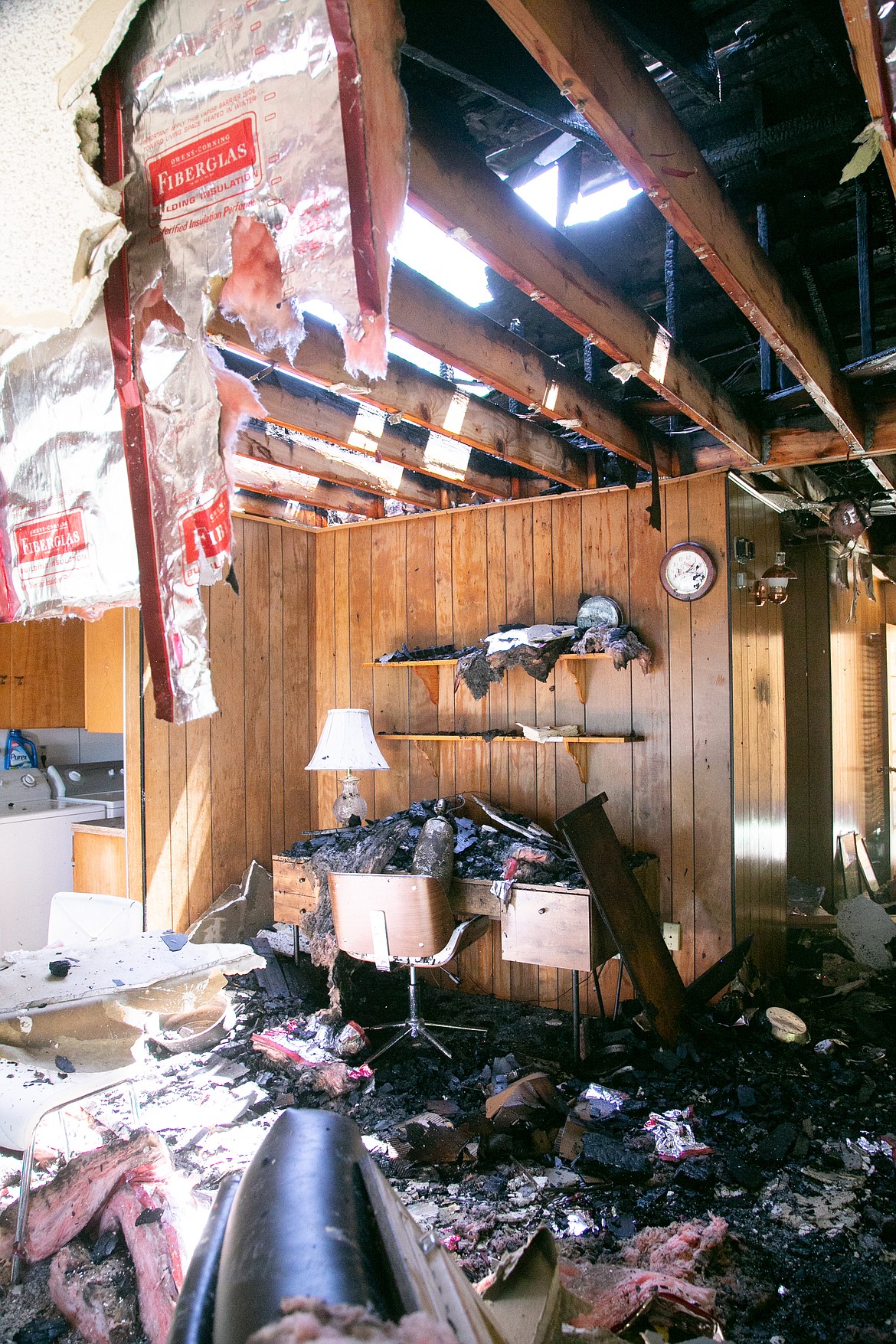 Tim Scofield, Sam Owen Fire Chief, helps gather the fire hose after containing the blaze with other fire crews from the Sagle area on Friday, June 4. Guest home of Steve Thorp suffered fire damage, the cause of the blaze remains unknown.