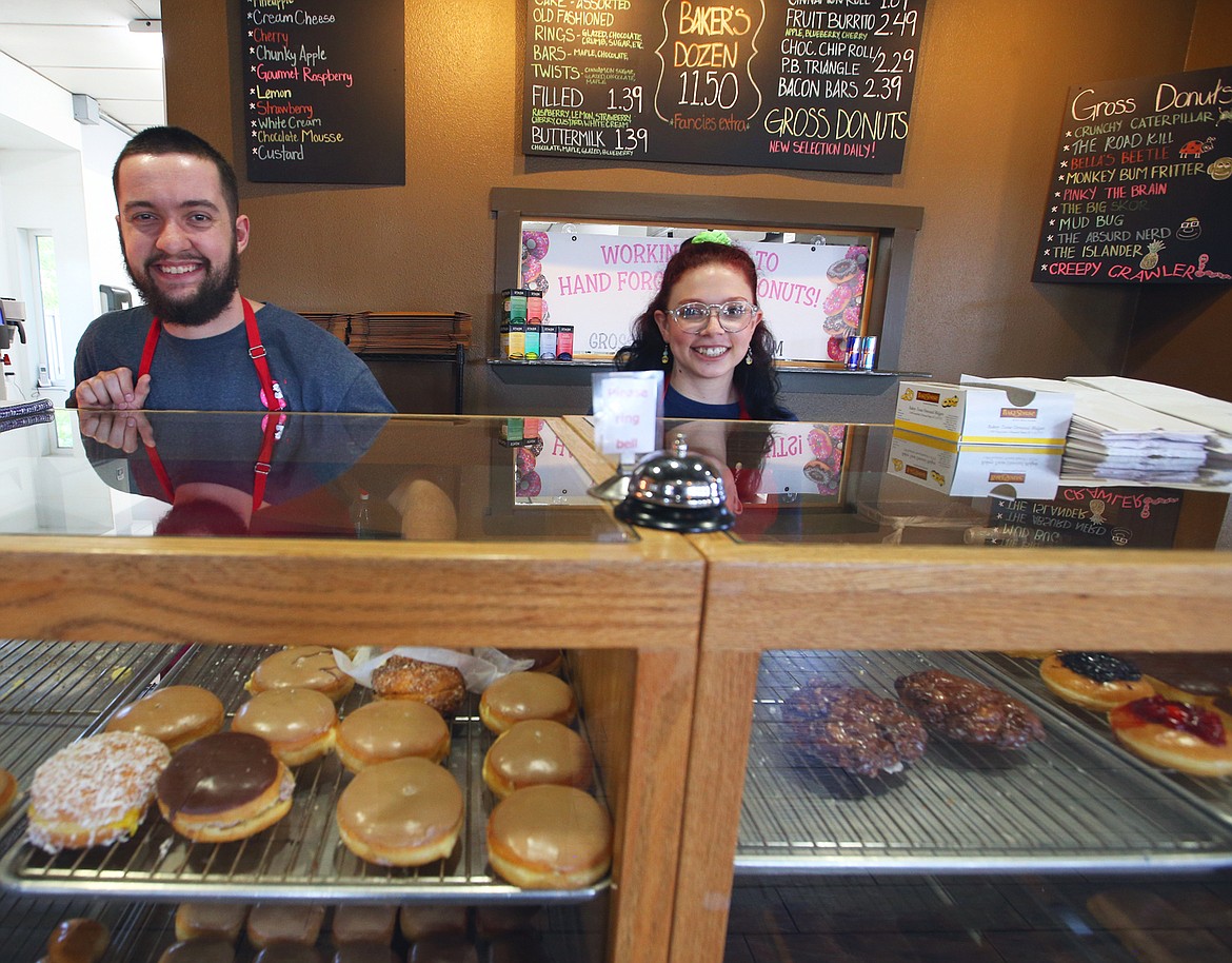 Brandon Webb, general manager with Gross Donuts, and employee Kali Boyce serve up fresh doughnuts on Friday in Coeur d'Alene.