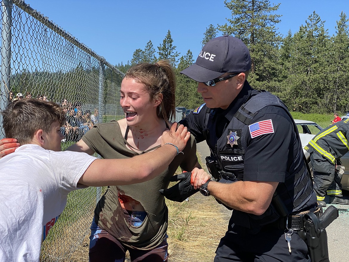 Lakeland High School senior Sydnee Hostetler reaches over to fellow classmate Colton Dow, left, for comfort during a mock DUI performance Friday morning. (MADISON HARDY/Press)