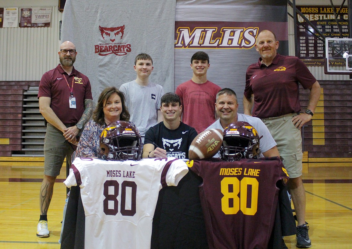 From the top left, Moses Lake High School assistant athletic director Clint Scriven, Alex Johnson, Ryan Johnson, football coach Todd Griffith, Suzanne Johnson, Brandon Johnson and Jeff Johnson gather together at the high school to celebrate Brandon Johnson signing with Willamette University to play football.