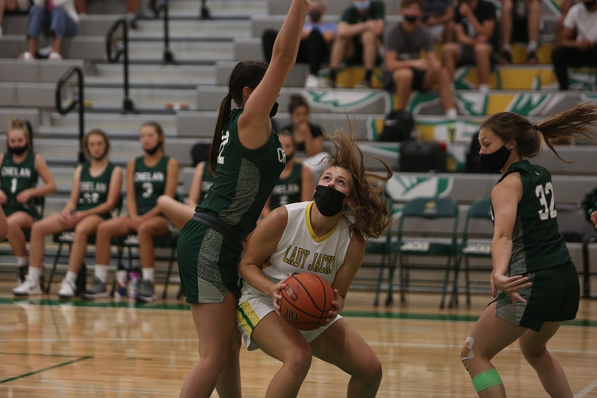 Quincy High School's Emily Wurl looks to go up for a shot beneath the basket with a pair of Chelan players contesting on Friday night at Quincy High School.
