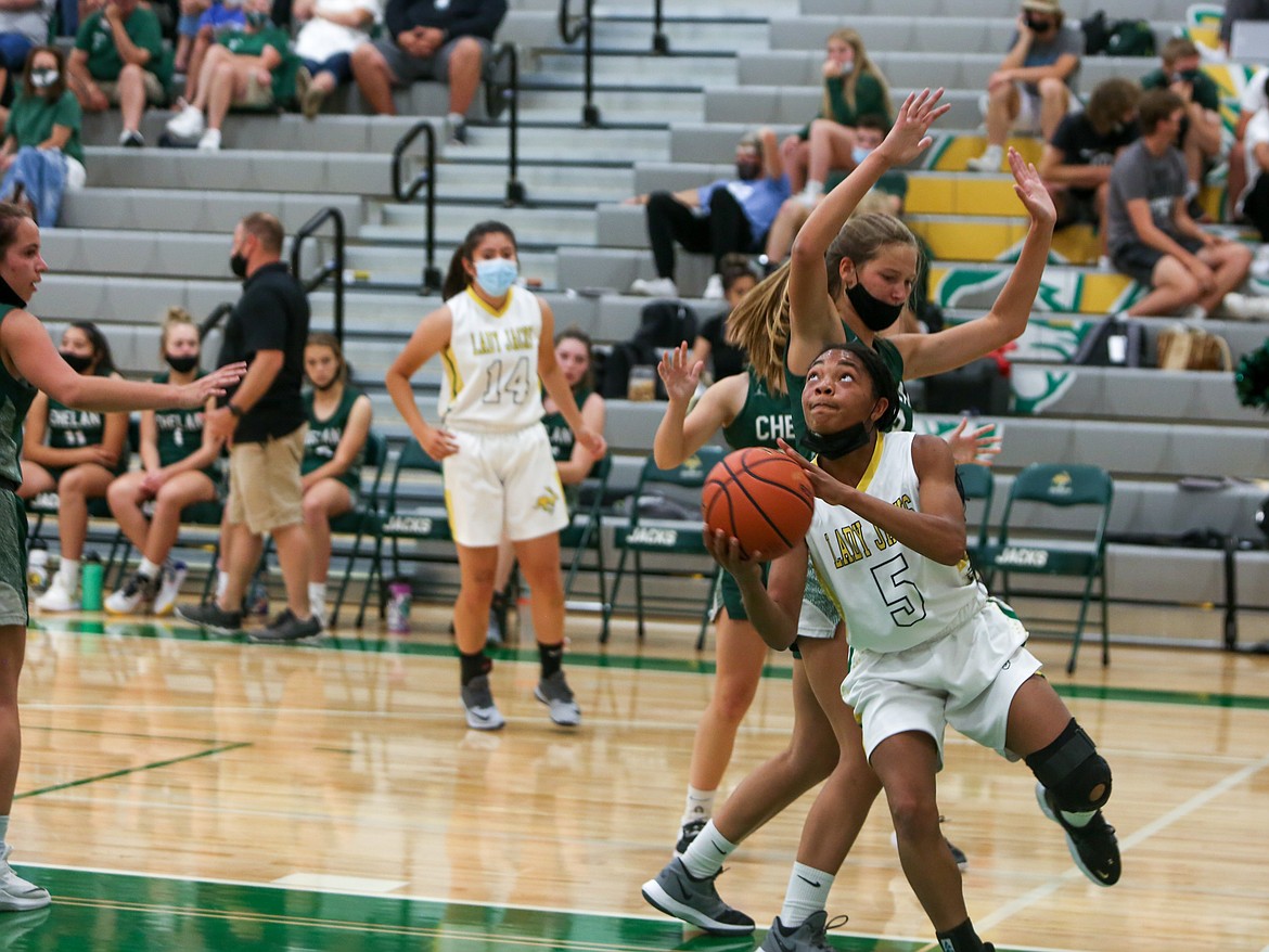 Joceline Schaapman dips under the Chelan High School player for a shot for Quincy High School on Friday night at home in Quincy.