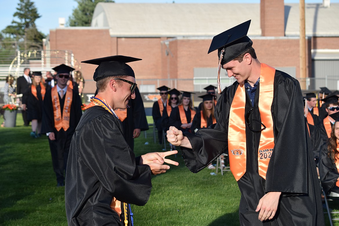 A pair of seniors play rock-paper-scissors during the procession at Ephrata High School’s 2021 graduation ceremony on Friday.