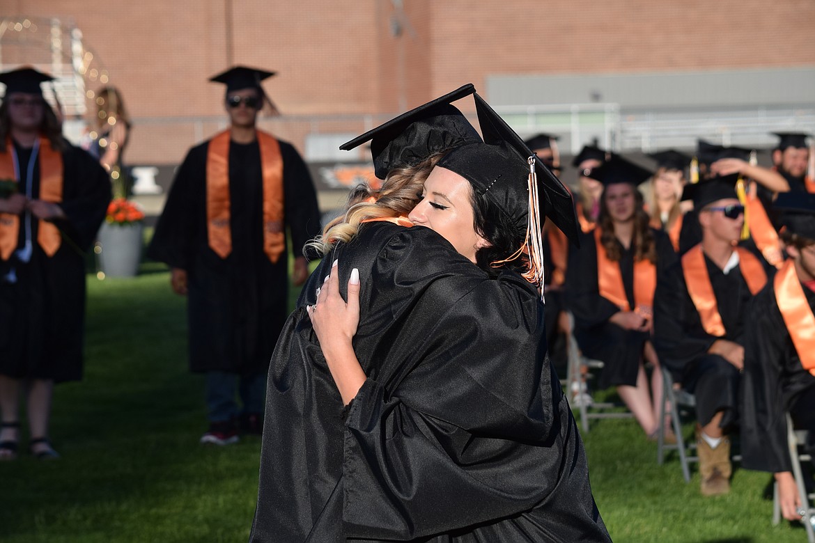 A pair of seniors hug during the procession at Ephrata High School’s 2021 graduation ceremony on Friday.
