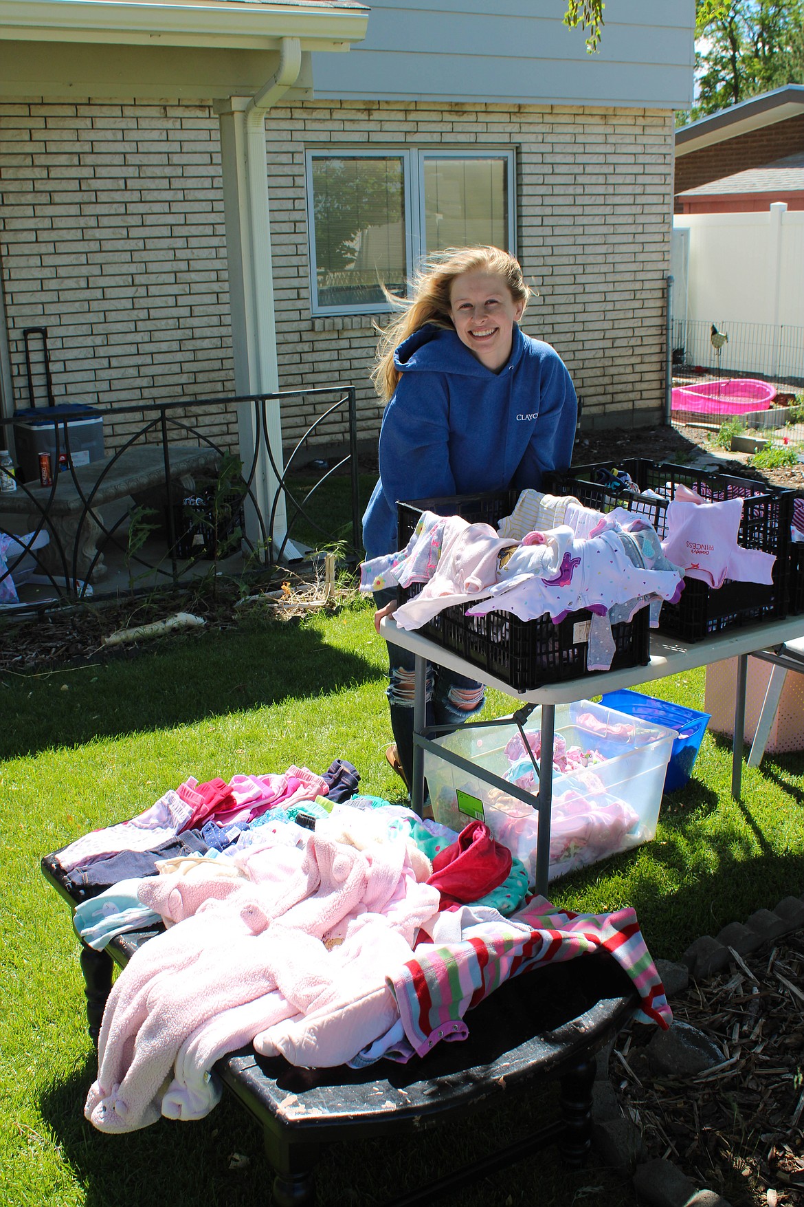 Cassidy Williams stands before her baby clothes at Saturday’s yard sale extravaganza in Moses Lake.