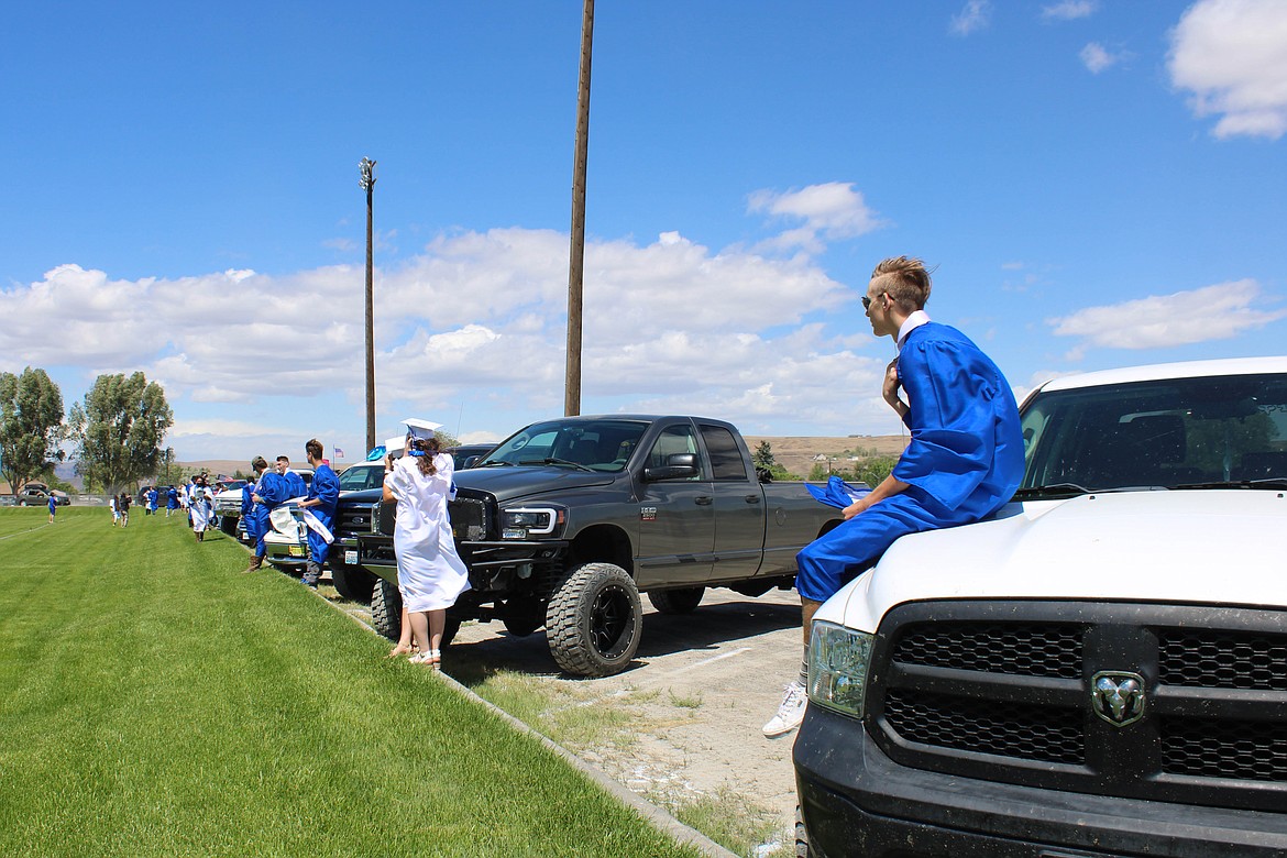 Soap Lake High School Graduates wait by their cars before Saturday's commencement ceremony.