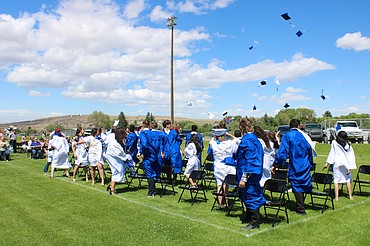 Soap Lake High School and Rise Academy graduates toss their caps after the commencement ceremony on Saturday.
