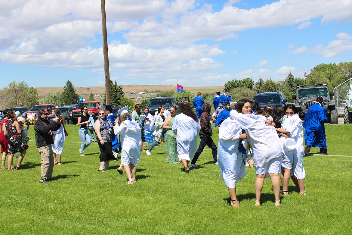 Soap Lake High School and Rise Academy graduates embrace each other and their families post-graduation on Saturday.