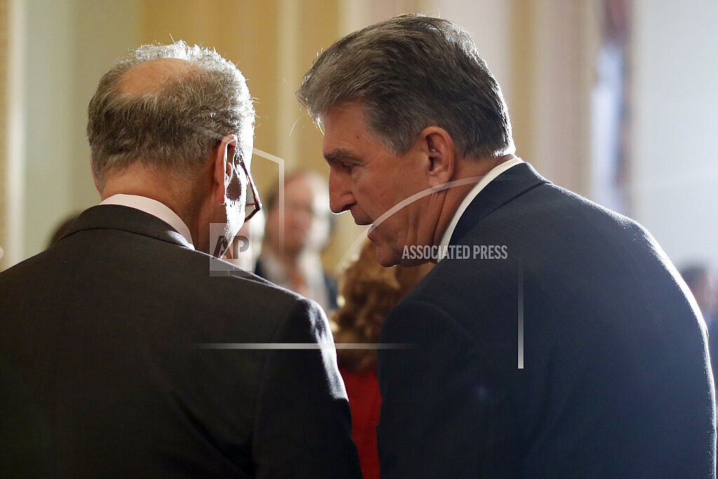 In this May 2, 2017, file photo, Sen. Joe Manchin, D-W.Va., right, speaks to then-Senate Minority Leader Charles Schumer, D-N.Y. during a news conference on Capitol Hill in Washington. Schumer warned his Democratic colleagues that June will "test our resolve" as senators return Monday to consider infrastructure, voting rights and other priorities. Six months into Democrats' hold on Washington, the senators are under enormous pressure to make gains on Democrats' campaign promises. (AP Photo/Carolyn Kaster, File)