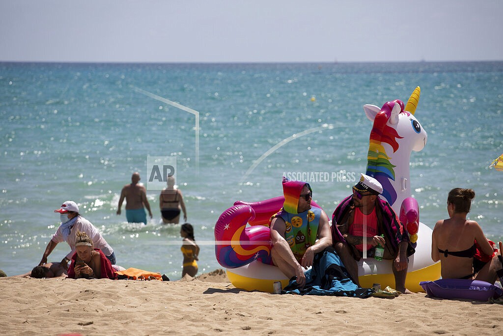 Tourists sunbathe on the beach at the Spanish Balearic Island of Mallorca, Spain, Monday, June 7, 2021. Spain is jumpstarting its summer tourism season by welcoming vaccinated visitors from most countries as well as European visitors who can prove they are not infected with coronavirus. It also reopened its ports to cruise ship stops on Monday. (AP Photo/Francisco Ubilla)