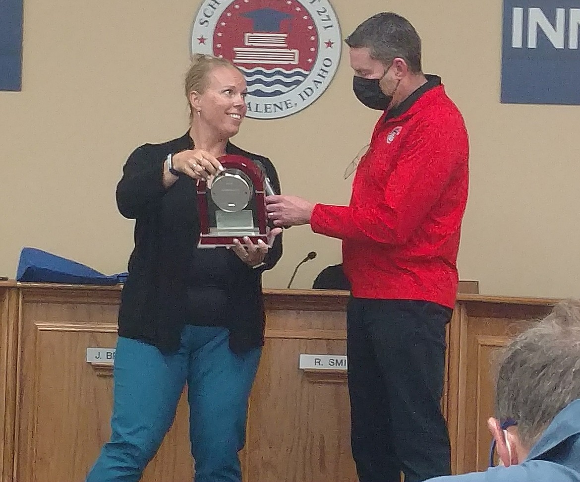 Coeur d'Alene School Board Chair Jen Brumley honors Superintendent Steve Cook with an award Monday evening. Cook will depart from the district at the end of the month.