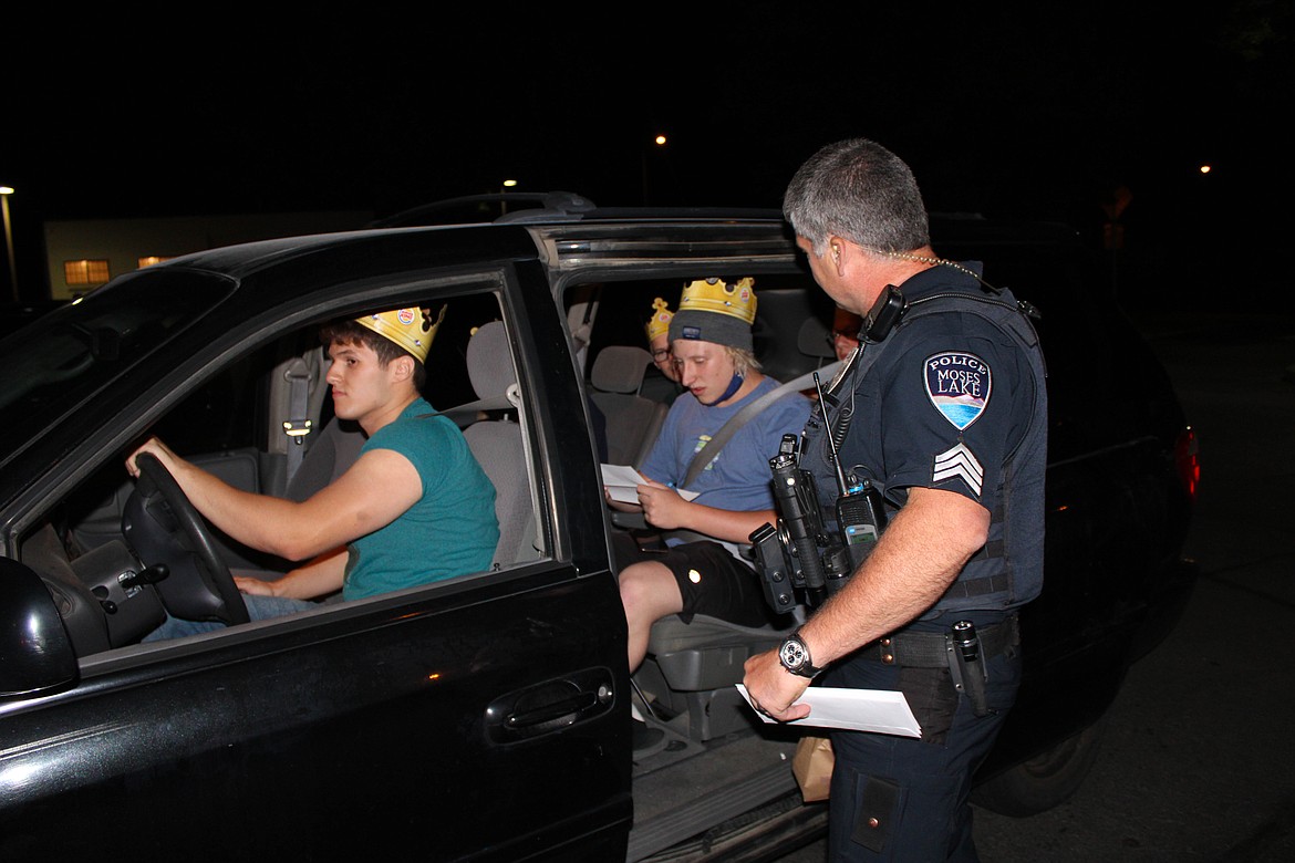 Sgt. Jeff Sursley trades burgers for scavenger hunt clues for the Moses Lake Christian Academy senior night.