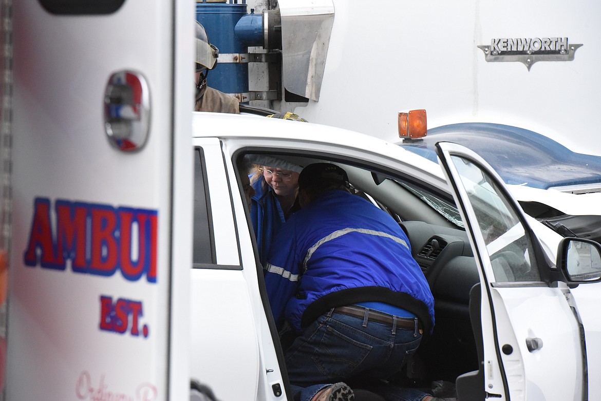 Paramedics with the Libby Volunteer Ambulance service treat a motorist involved in a wreck at the corner of U.S. Highway 2 and Minnesota Avenue on June 8. (Derrick Perkins/The Western News)