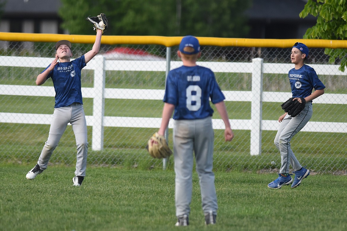 Ryder Hamilton makes a catch in left field against Whitefish Monday as teammates Jonah Wynne (8) and Quinn Kerr look on.
Jeremy Weber/Bigfork Eagle