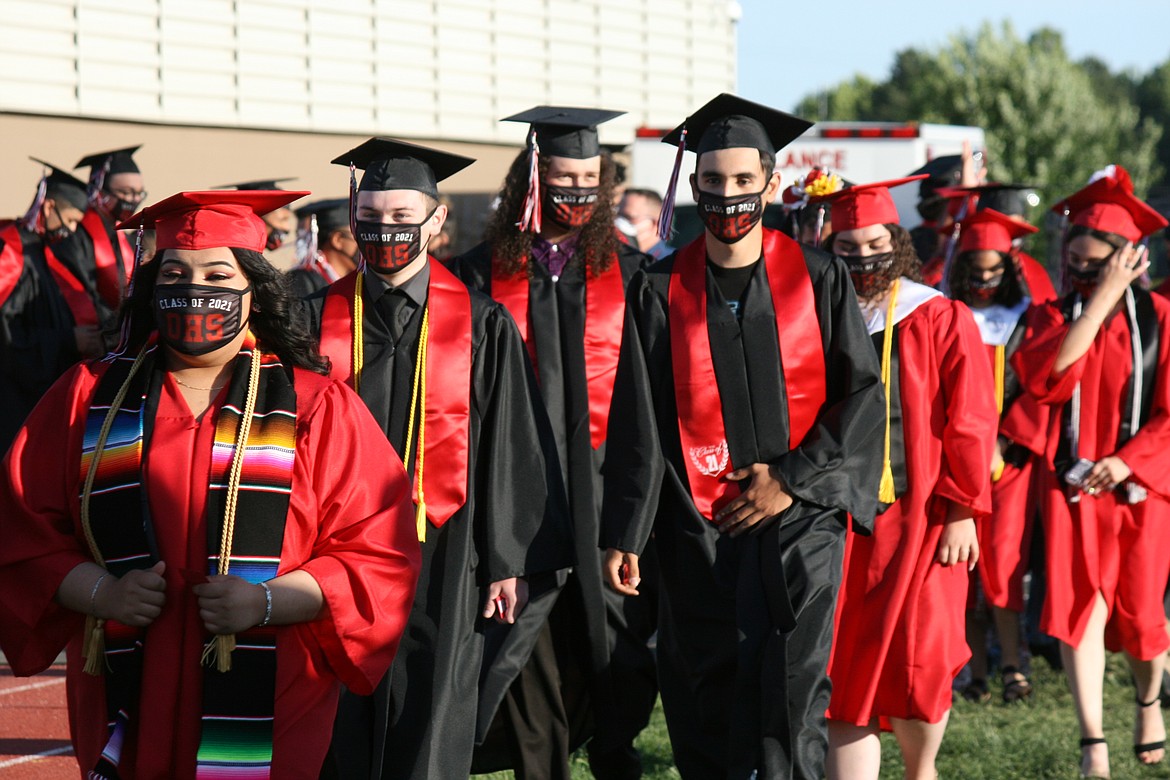 Othello High School seniors enter Huskie Stadium during graduation ceremonies Friday.