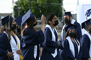 A Desert Oasis High School graduate waves to her family during graduation ceremonies June 7 in Othello.