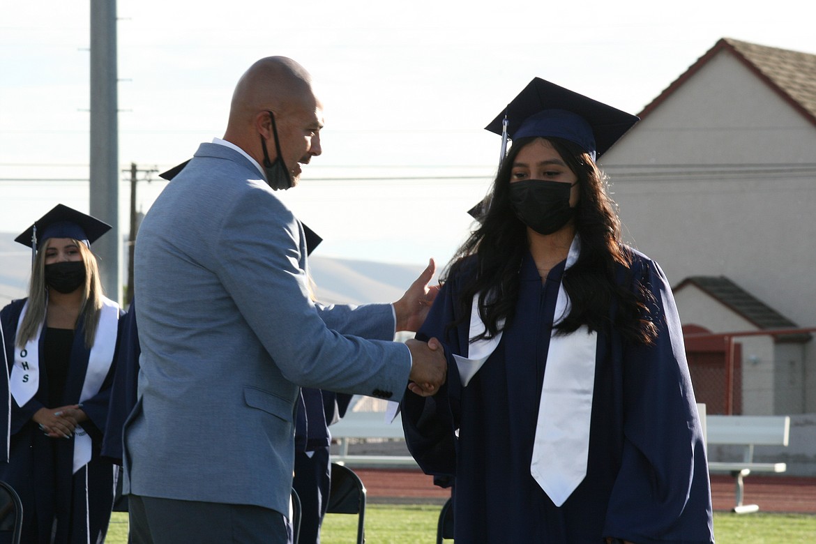 Desert Oasis High School principal Josh Tovar (left) shakes hands with a graduate during ceremonies June 7 in Othello.