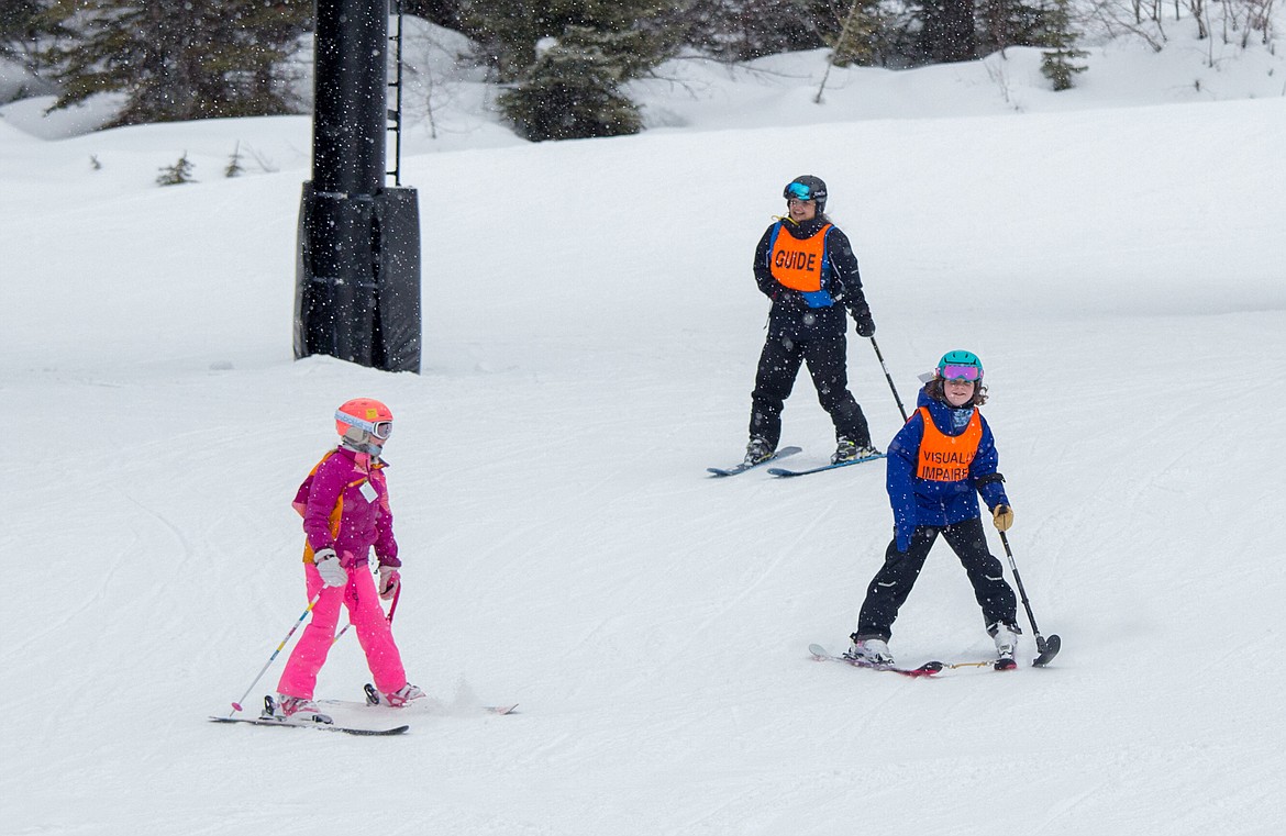 Kate Cooke, right, skis with her DREAM Adaptive instructor Sylvia Lundquist and her friend in February 2020. (Photo courtesy of DREAM Adaptive)