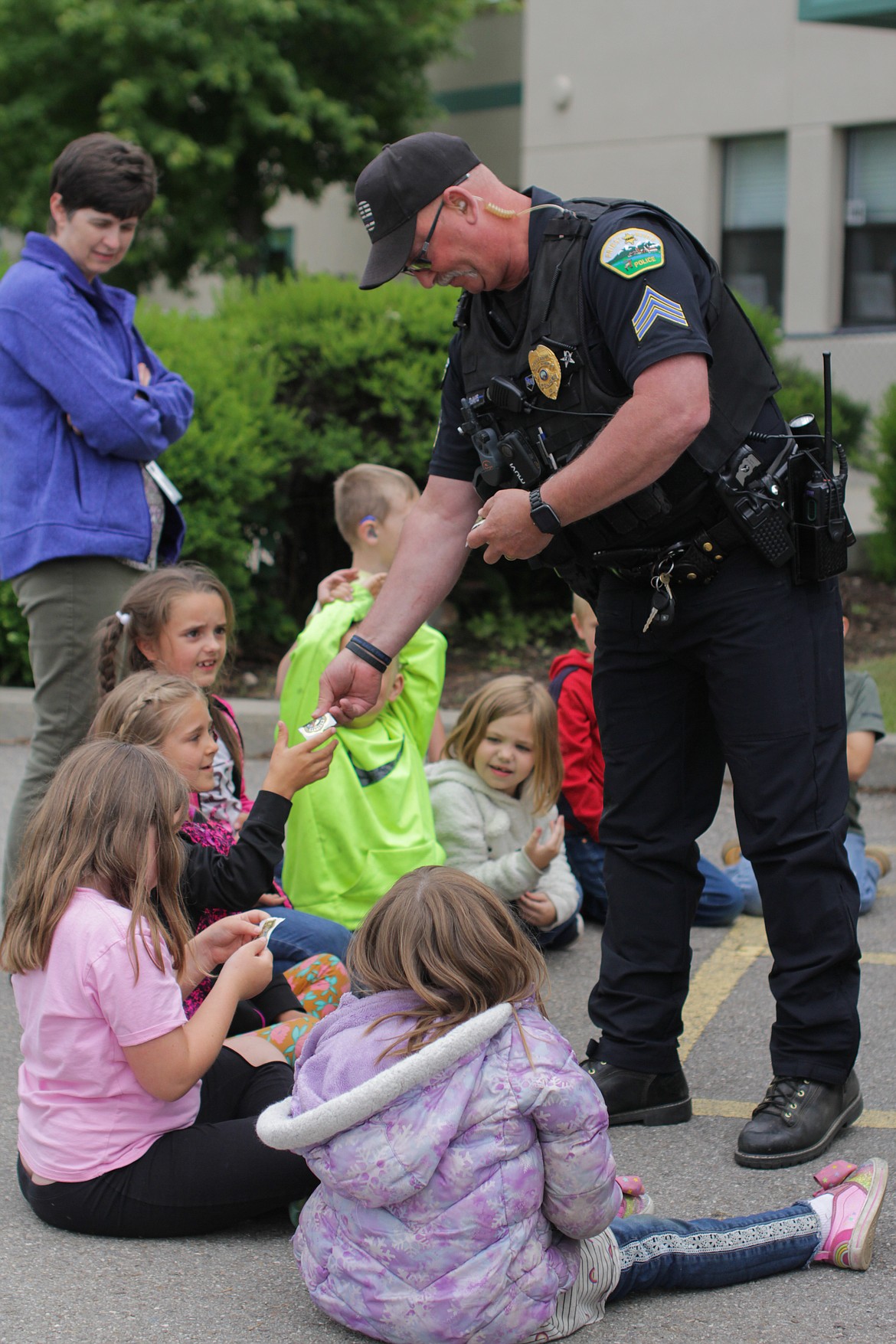Sgt. Chris Davis gives stickers to students at the end of his presentation on bicycle safety at Idaho Hill Elementary Wednesday.