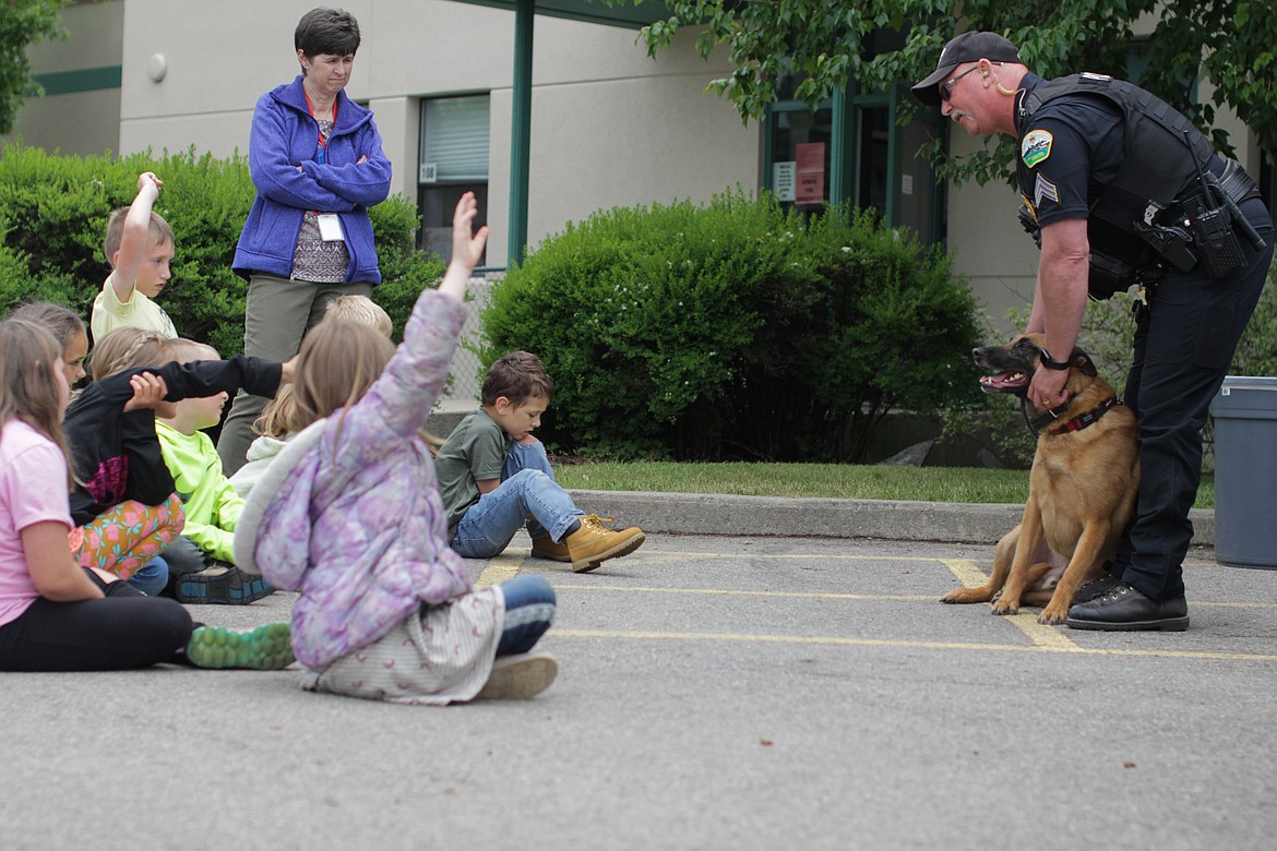 Students meet Cisco the dog during Sgt. Chris Davis's presentation on bicycle safety.