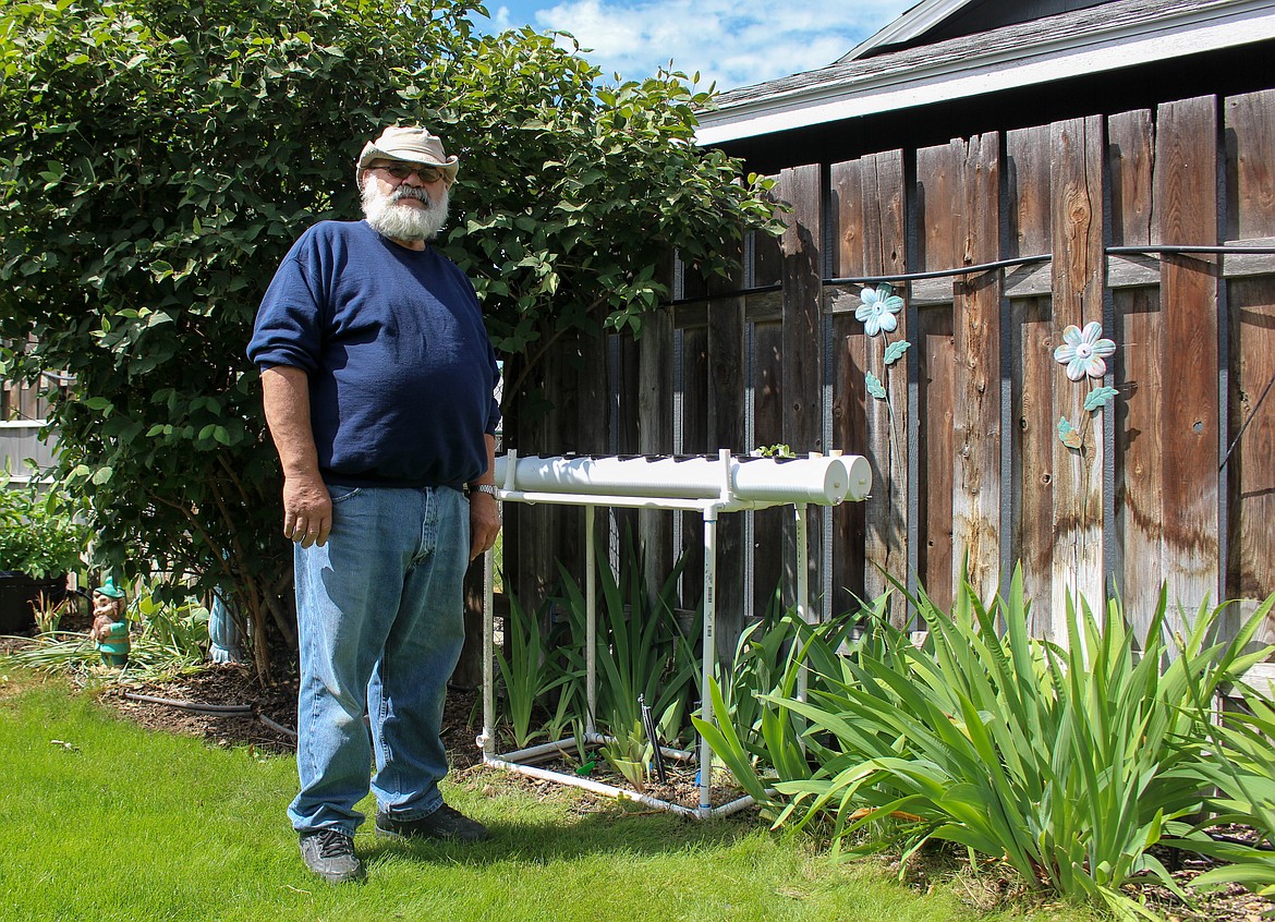 Ken Rosecrans of Moses Lake stands beside his hydroponic growing setup in his backyard on Wednesday morning.