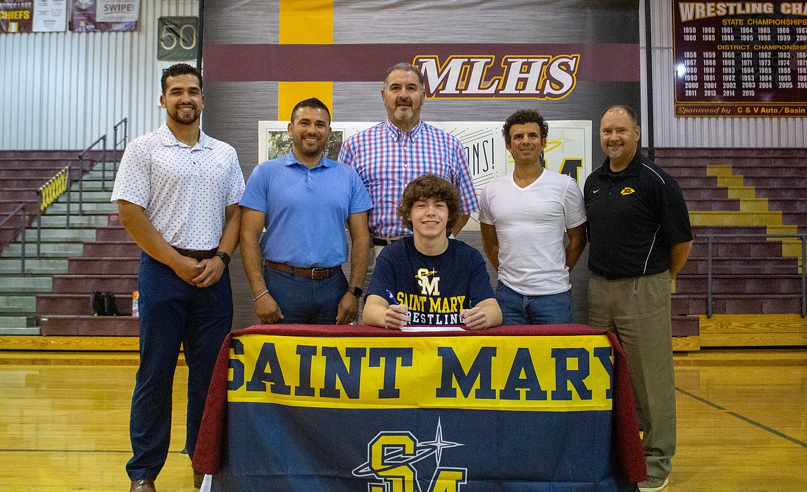 Left to right, Moses Lake wrestling coaches Jordan Lacelle, Ariel Garza, Jim Nielsen, Jaime Garza and Moses Lake Athletic Director Loren Sandhop join senior Hunter White as he signs with University of Saint Mary to continue his wrestling career on Thursday.