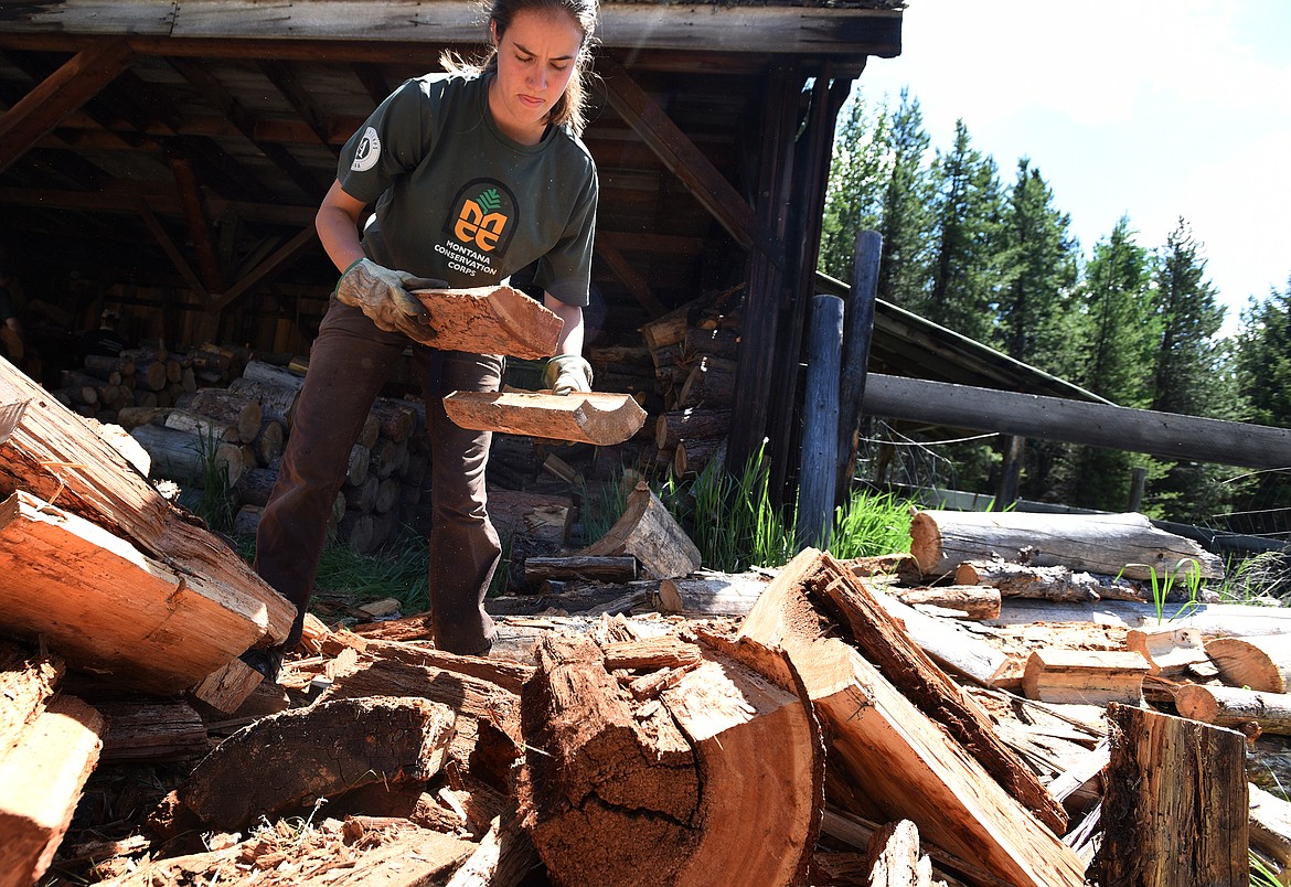 Emily Brown of the Montana Youth Conservation Corps works to help stack firewood at Camp Ponderosa Friday, June 4. (Jeremy Weber/Daily Inter Lake)