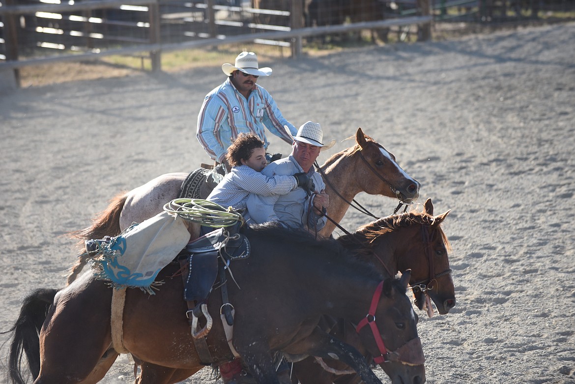 Davyn Daroche gets a lift from one of the pickup riders at last Saturday’s Hot Springs Rodeo during the ranch broncs event. (Scott Shindledecker/Valley Press)