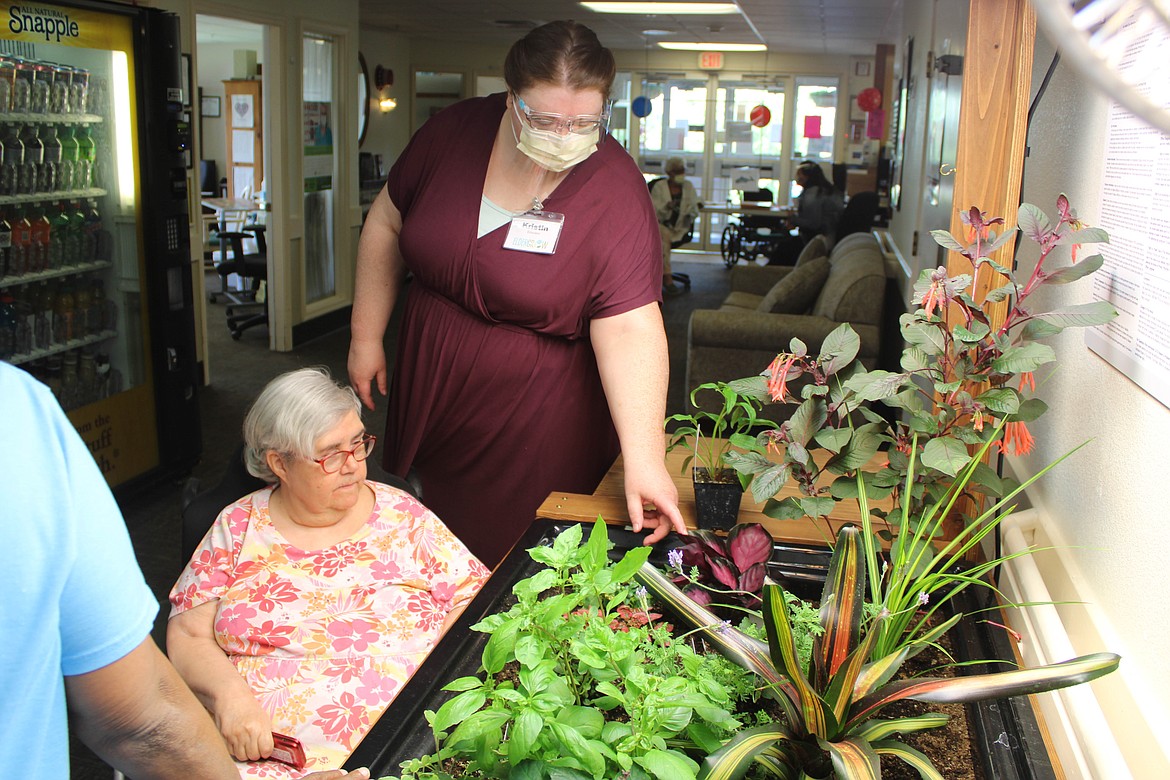 Lake Ridge Center residents Tony Coates (front) and Billie Mathers (behind) plant new flowers at a recent Eldergrow workshop.