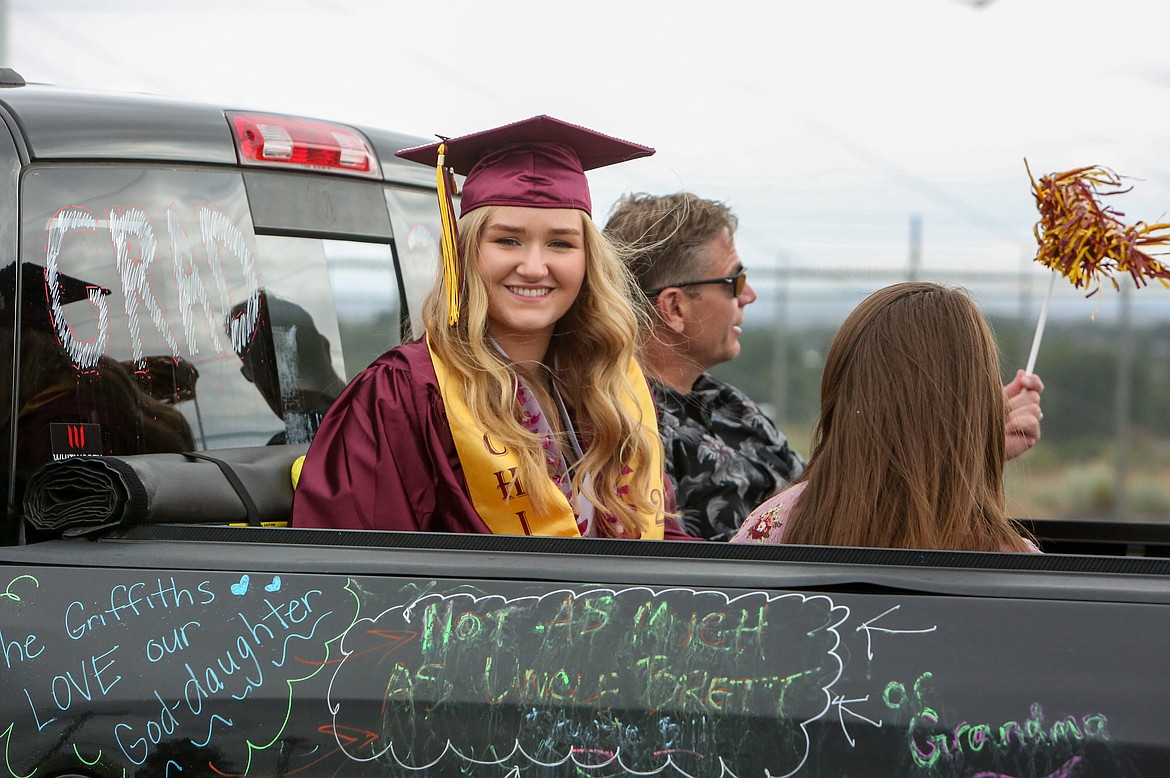 Graduate Avery Sandhop rides in the back of her family’s truck down Airway Drive Northeast as the Moses Lake High School graduation parade departs the Grant County Fairgrounds Friday afternoon.