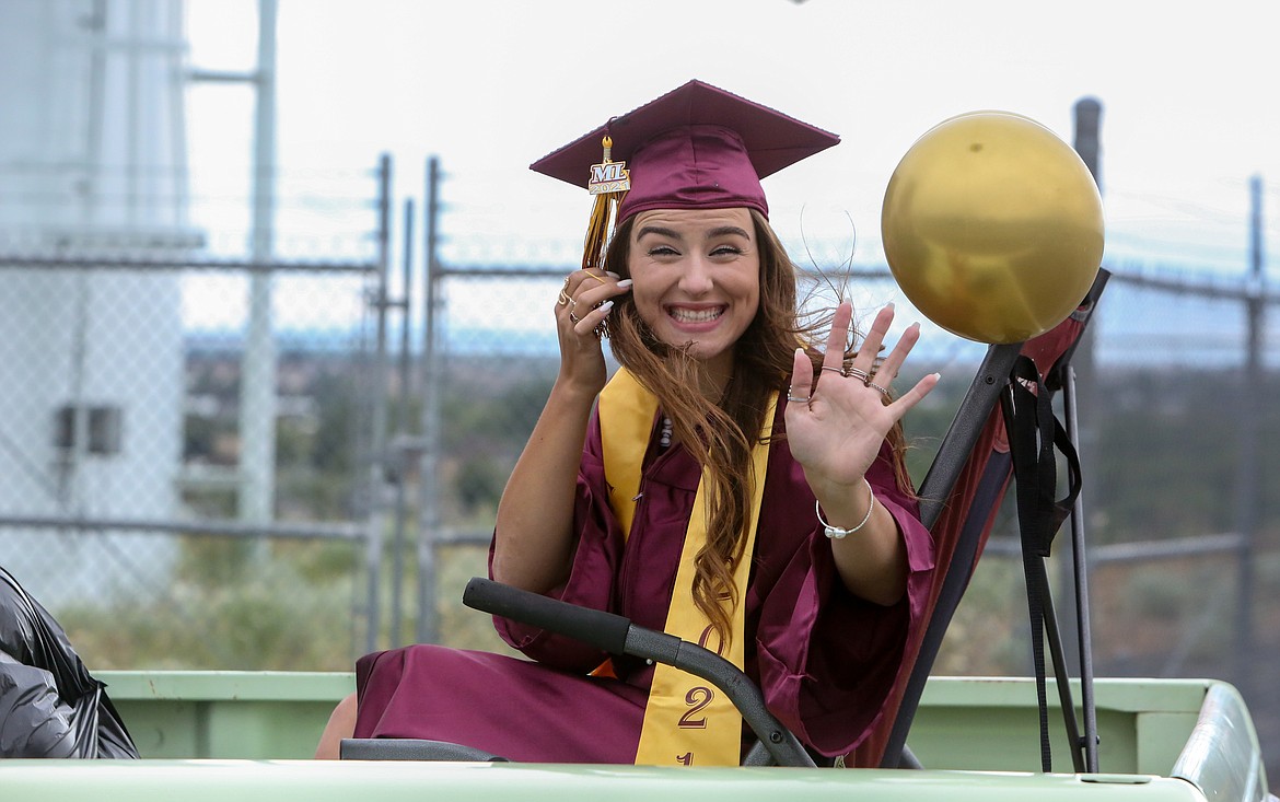 Graduating senior Ciarrah Knoll waves as she passes by the Grant County Fairgrounds as the Moses Lake High School graduation parade departs on Friday, June 11.