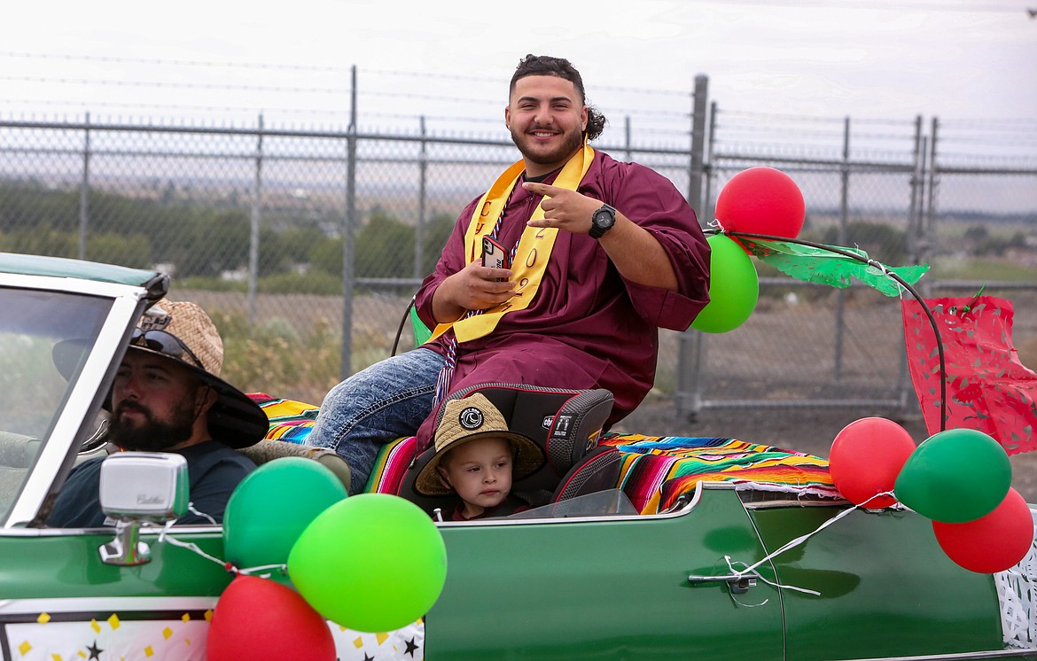 Alex Suarez poses for the camera as he leaves the Grant County Fairgrounds on Friday afternoon as part of the 2021 Moses Lake High School graduation parade ceremony.