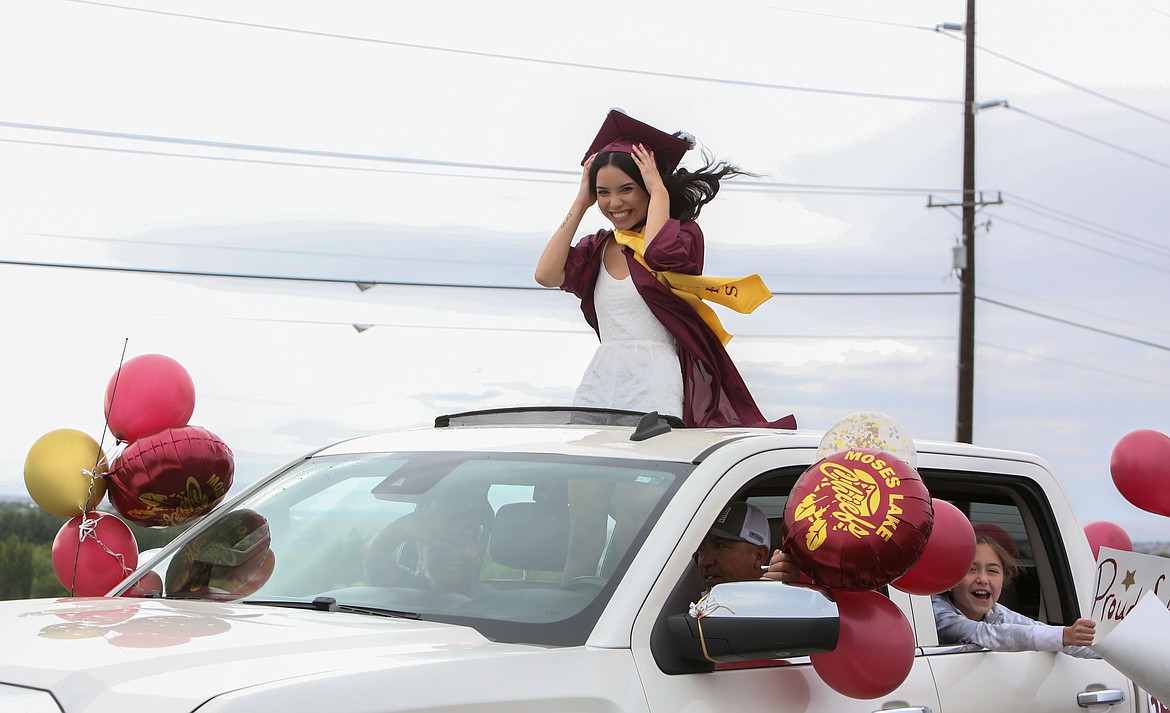 A 2021 Moses Lake High School graduate does her best to hold on to her cap as she heads down Airway Drive Northeast as part of the graduation parade ceremony on Friday, June 11